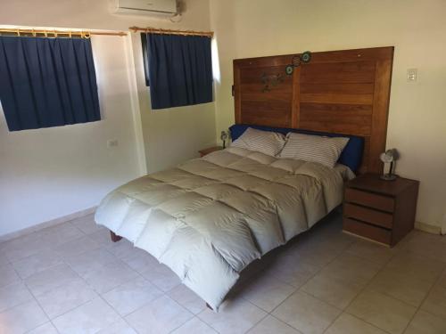 1 dormitorio con 1 cama grande y cabecero de madera en Campo sereno en 