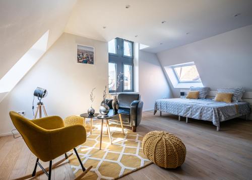 een slaapkamer met een bed en een tafel en stoelen bij Les Camuches in Tournai