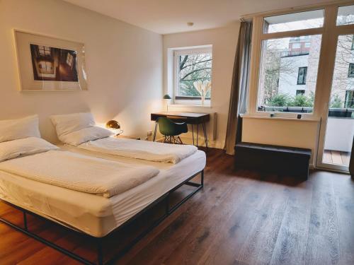 1 dormitorio con 2 camas, escritorio y ventana en 200m zum Bahnhof nach Hamburg, 180cm x 200cm Doppelbett en Ahrensburg