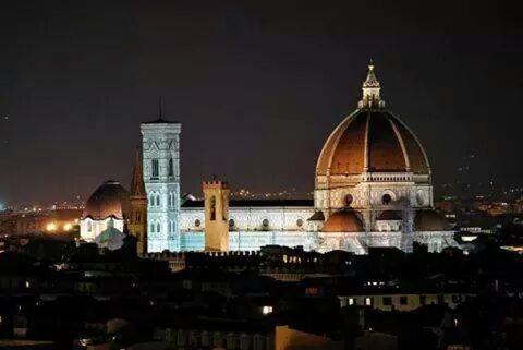 a large building with a clock tower at night at Housenovoli in Florence