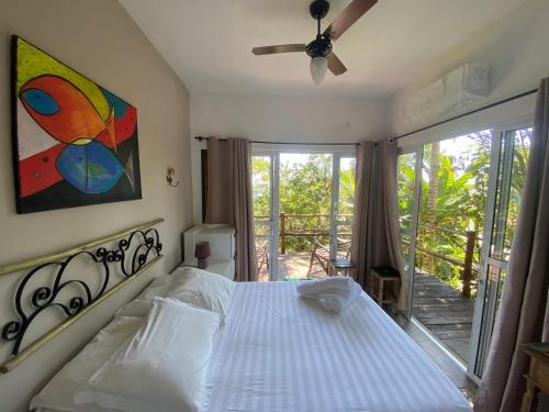 1 dormitorio con 1 cama y balcón en Recanto Ipê Amarelo, en Paraty