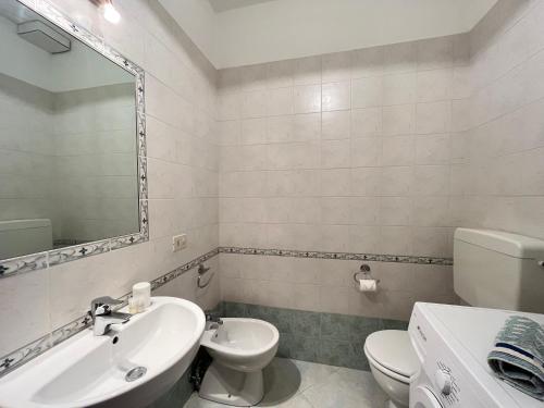 bagno con lavandino, servizi igienici e specchio di Appartamento Ceula a Levanto