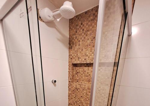 La salle de bains est pourvue d'une douche avec une porte en verre. dans l'établissement Pacha - Bangalôs em Pipa, à Pipa
