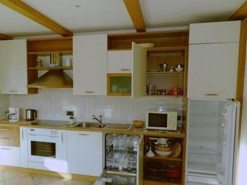 a kitchen with white appliances and wooden cabinets at Ciasa Gran Panorama Moena in Moena