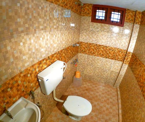 a bathroom with a toilet and a sink at Shalom Palace in Cochin