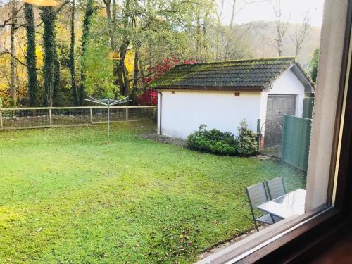 a view of a yard with a white building at River house in Birnam