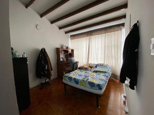 - une chambre avec un lit dans une pièce dotée d'une fenêtre dans l'établissement La Casa de Lu Los Rosales, à Manizales