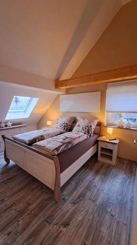 a bedroom with a large bed and two windows at Ferienwohnung Sternenstube in Völkenroth