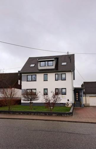 a white house with a black roof at Ferienwohnung Sternenstube in Völkenroth