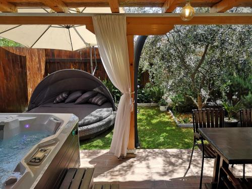 um quintal com uma banheira de hidromassagem e um pátio com uma mesa em Apartment Vespa & Jacuzzi em Split