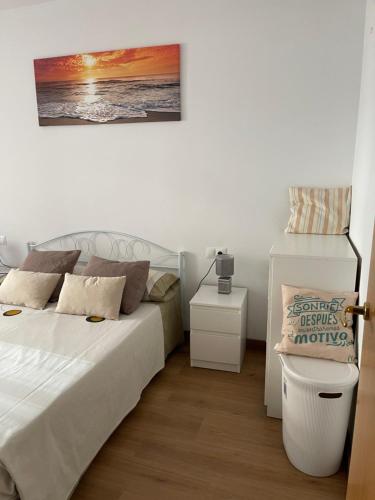 ein Schlafzimmer mit einem Bett und einem Tisch mit einem Bild an der Wand in der Unterkunft Apartameto Verena Deluxe in Guardiola de Berga