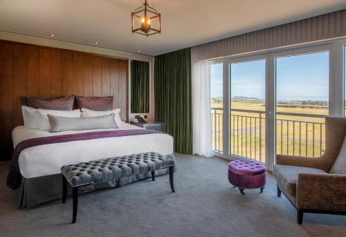 a bedroom with a large bed and a balcony at Old Course Hotel St Andrews in St. Andrews