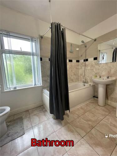 W łazience znajduje się prysznic, wanna i umywalka. w obiekcie Cheerful 2 bedroom mid terrace house in BD2 w mieście Bradford