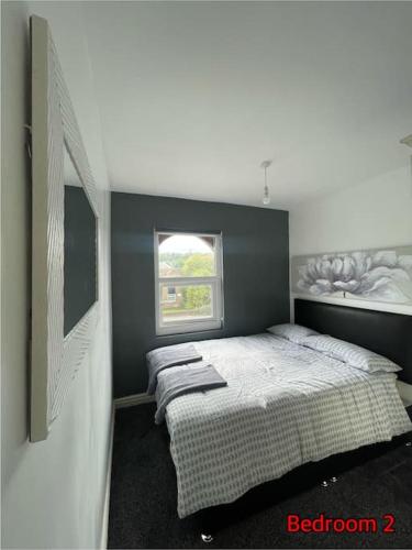 a bedroom with a bed and a window at Cheerful 2 bedroom mid terrace house in BD2 in Bradford