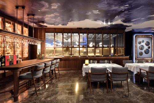 a restaurant with tables and chairs and a bar at EPIC SANA Algarve Hotel in Albufeira