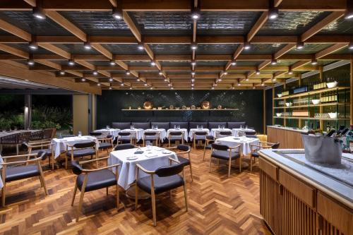 a restaurant with tables and chairs and a bar at EPIC SANA Algarve Hotel in Albufeira