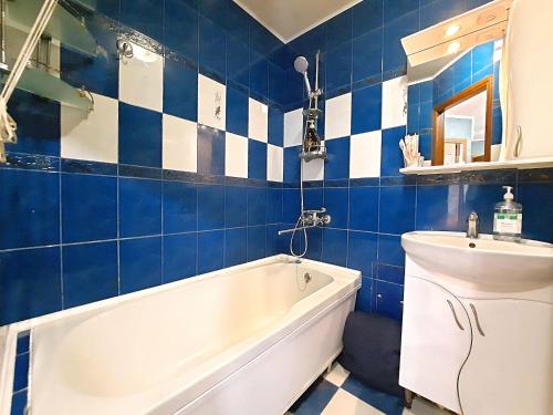 a blue and white bathroom with a tub and a sink at Слава Героям 11 Сеть апартаментов Alex Apartments Бесконтактное заселение 24-7 in Poltava