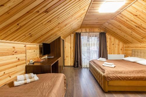 a bedroom with two beds and a desk and a television at Spark in Bukovel