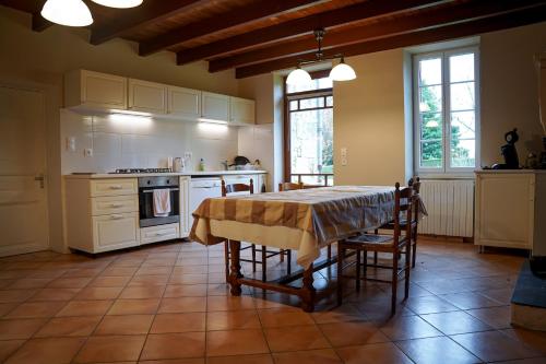 eine Küche mit einem Tisch und Stühlen in der Unterkunft Suite parentale de luxe in Rouffignac