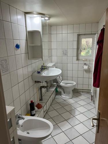 a bathroom with two sinks and a toilet at Zwei Eichen Gadenstedt in Ilsede