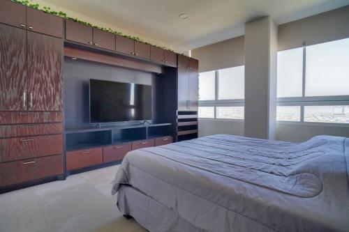1 dormitorio con 1 cama y TV de pantalla plana en Best Apt Luxury Modern New 2BR Gym Pool 3mins SPGG en Monterrey