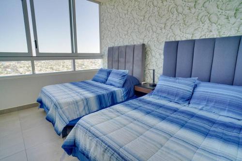 a bedroom with two beds and two windows at Best Apt Luxury Modern New 2BR Gym Pool 3mins SPGG in Monterrey