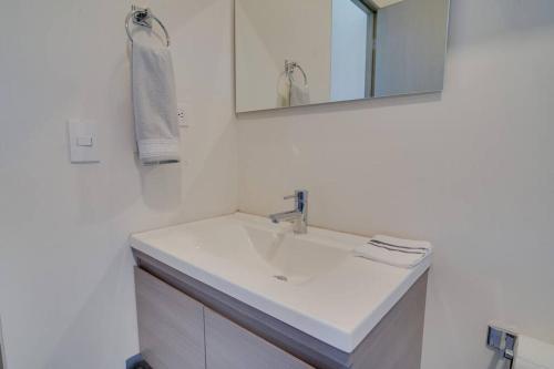 a white bathroom with a sink and a mirror at Best Apt Luxury Modern New 2BR Gym Pool 3mins SPGG in Monterrey