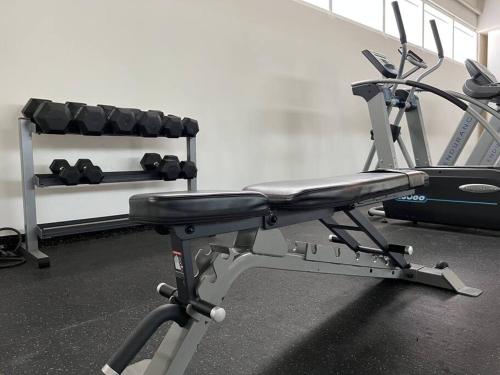 a gym room with a bench and weights at Best Apt Luxury Modern New 2BR Gym Pool 3mins SPGG in Monterrey