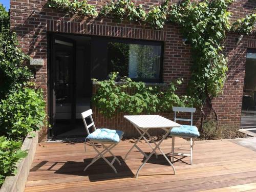 a table and two chairs on a wooden deck at 'het T-huisje' volledig ingerichte studio in Leuven