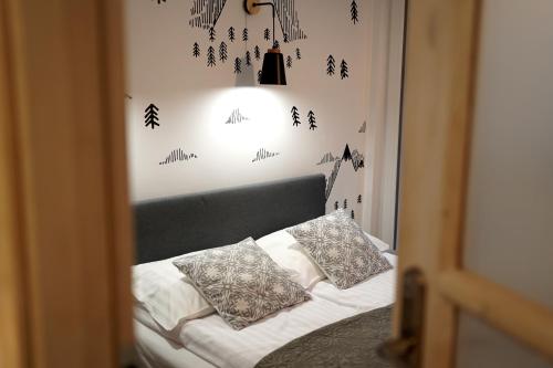a bedroom with a bed with a headboard and a light at Apartament Okna na Park in Polanica-Zdrój