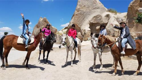 a group of people riding horses in the desert at Underground Cave Suites Hotel in Goreme