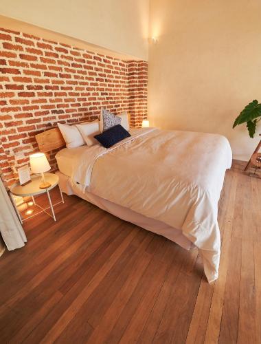 a bedroom with a large bed and a brick wall at Wayarumi Skyhotel in Carhuaz