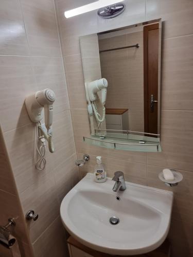 a bathroom with a white sink and a mirror at Borovets Ski&Spa Studio - Semiramida Garden A16 in Borovets