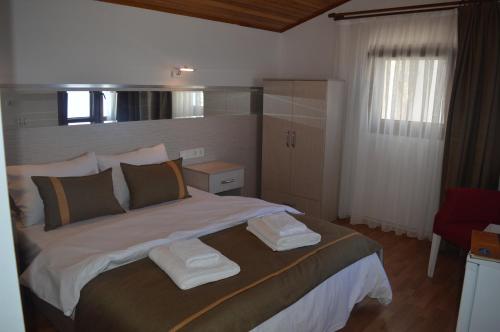 a bedroom with a large bed with towels on it at Yakamoz Otel in Urla