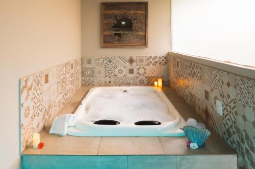 a bath tub in a bathroom with candles in it at Casa da Lua Pousada in Alto Paraíso de Goiás