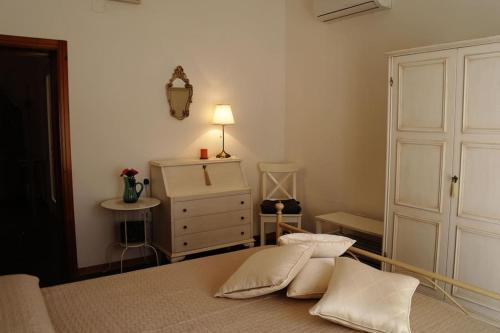 卡斯特拉納格羅泰的住宿－Casa Marisa Villa Vacanza，一间卧室配有一张床和一个带灯的梳妆台