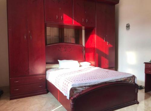 ein rotes Schlafzimmer mit einem Bett mit roten Schränken in der Unterkunft Comfort Room in Kairo