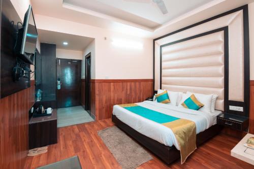 a bedroom with a bed and a flat screen tv at The Fern Residency Katra in Katra
