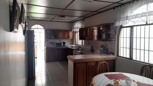 a kitchen with wooden cabinets and a counter top at Mario y Jeannette in Alajuela City