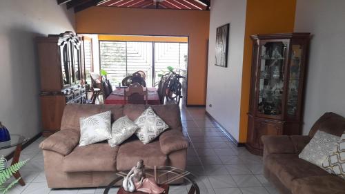 a living room with a couch and a dog in the distance at Mario y Jeannette in Alajuela City