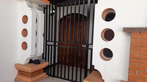 a black gate in a hallway with a brick wall at Mario y Jeannette in Alajuela City