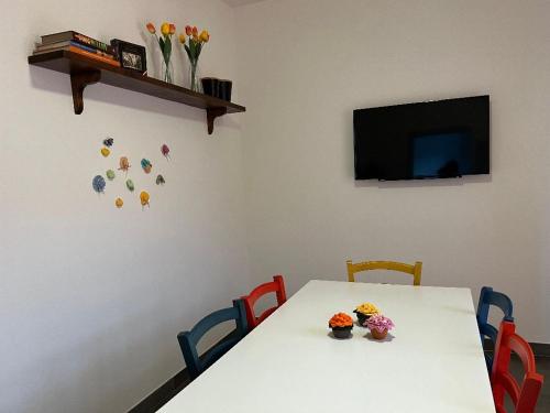 a dining room table with two chairs and a television at Antica Fonte holiday home in Tavullia
