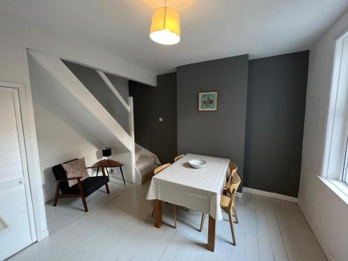 a dining room with a table and a chair at Charming house by the sea in Ryde