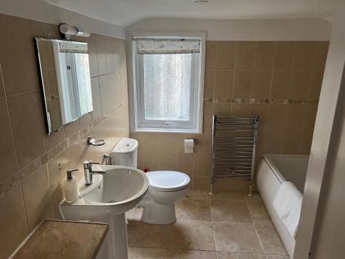 a bathroom with a sink and a toilet and a tub at Charming house by the sea in Ryde