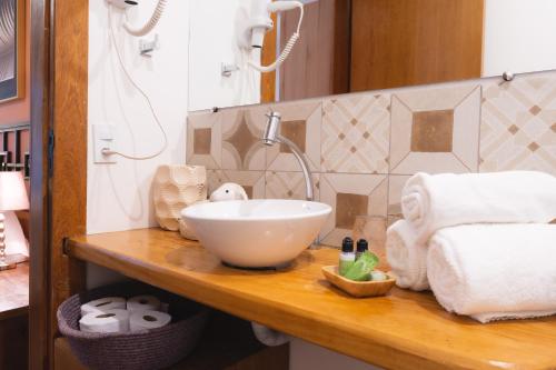 a bathroom with a sink and towels on a counter at Casa da Lua Pousada in Alto Paraíso de Goiás
