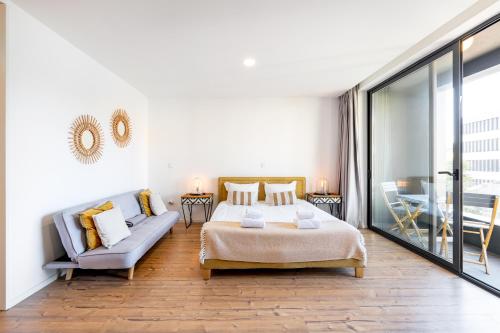 um quarto com uma cama, um sofá e uma mesa em in the MOOD no Porto