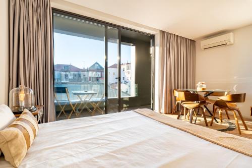 um quarto com uma cama, uma mesa e uma varanda em in the MOOD no Porto