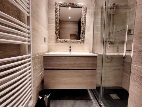 une salle de bain avec un lavabo et un miroir dans l'établissement Appartement T3 rénové, centre Les Gets, proche pistes, 6 pers, balcon, parking, équipements complets - FR-1-598-30, aux Gets