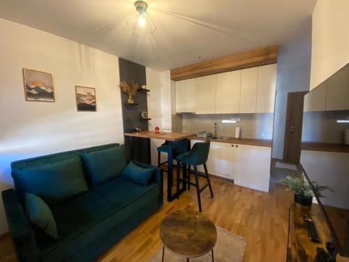 een woonkamer met een bank en een tafel en een keuken bij Zlatiborika Spa&Lux Apartment in Zlatibor