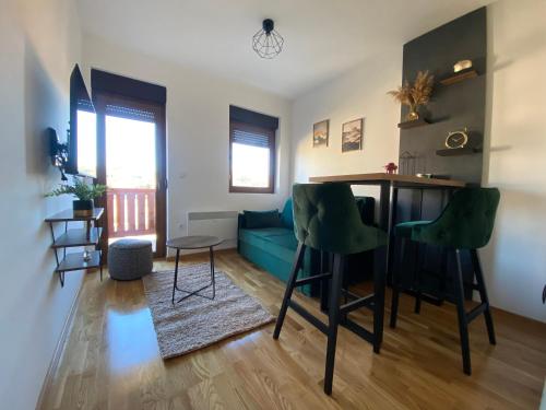 een woonkamer met een tafel en een blauwe bank bij Zlatiborika Spa&Lux Apartment in Zlatibor